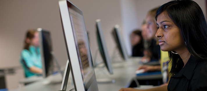 A student working on a computer in the Mac lab